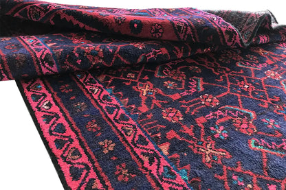 Oriental rug runner with a rolled edge and colorful patterns in pink and blue