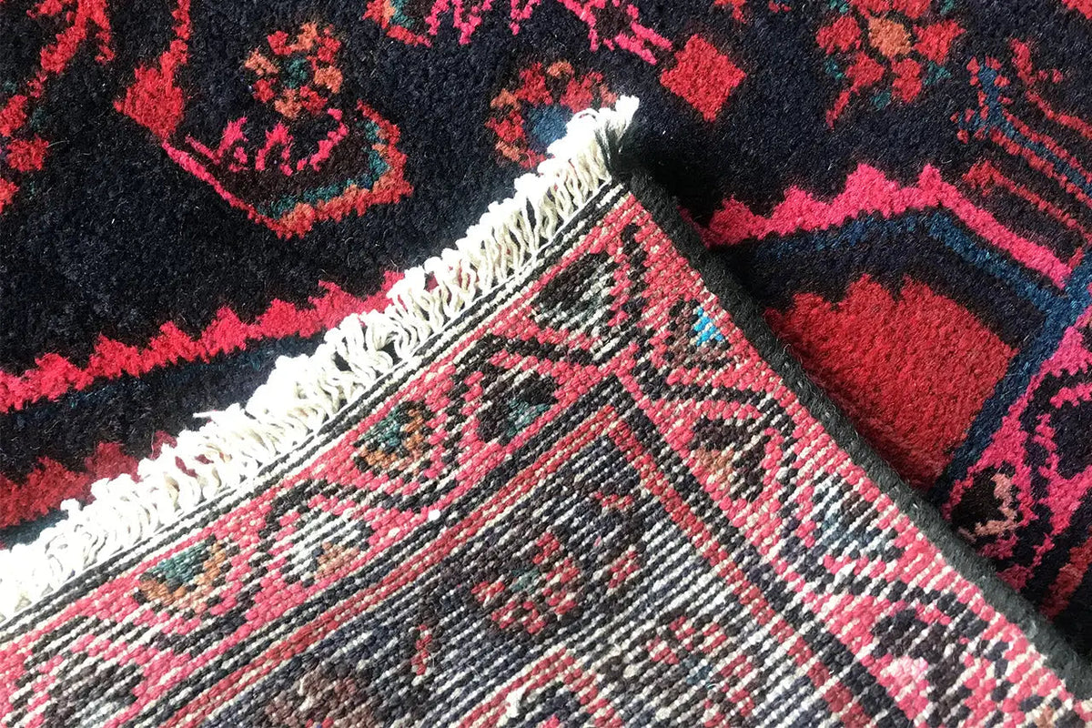 Oriental rug runner with fringed edge; detail of the pile texture and pattern in pink and blue