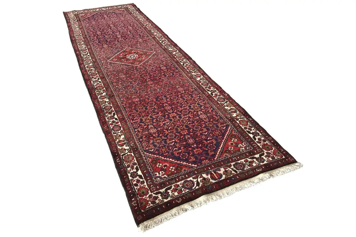 Runner rug with a twisted lounging angle, red medallion pattern, and fringes