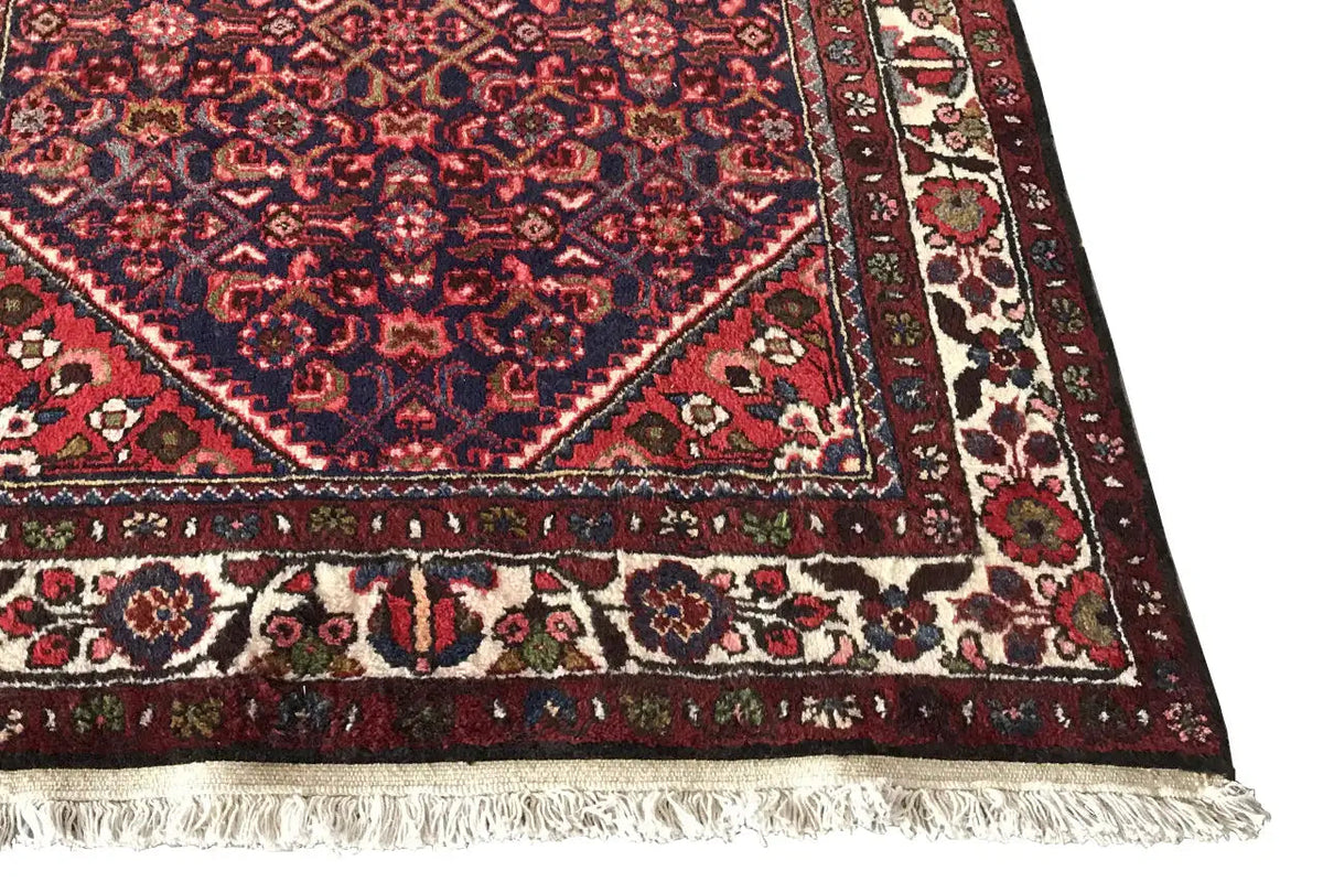 Carpet runner corner with floral motifs, reddish-brown field and fringes along the bottom edge