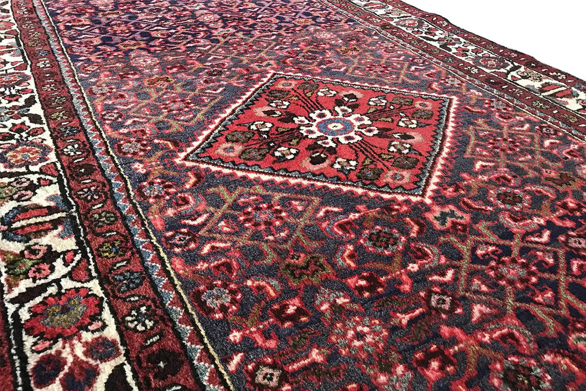 Close-up of a carpet runner: red field with a medallion and fine rows of ornaments