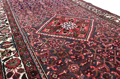 Close-up of a carpet runner: red field with a medallion and fine rows of ornaments