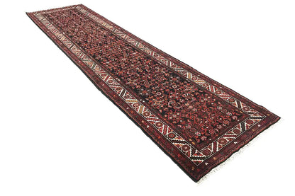 Oriental rug runner, dark red hues with a delicate border, laid lengthwise, fringes