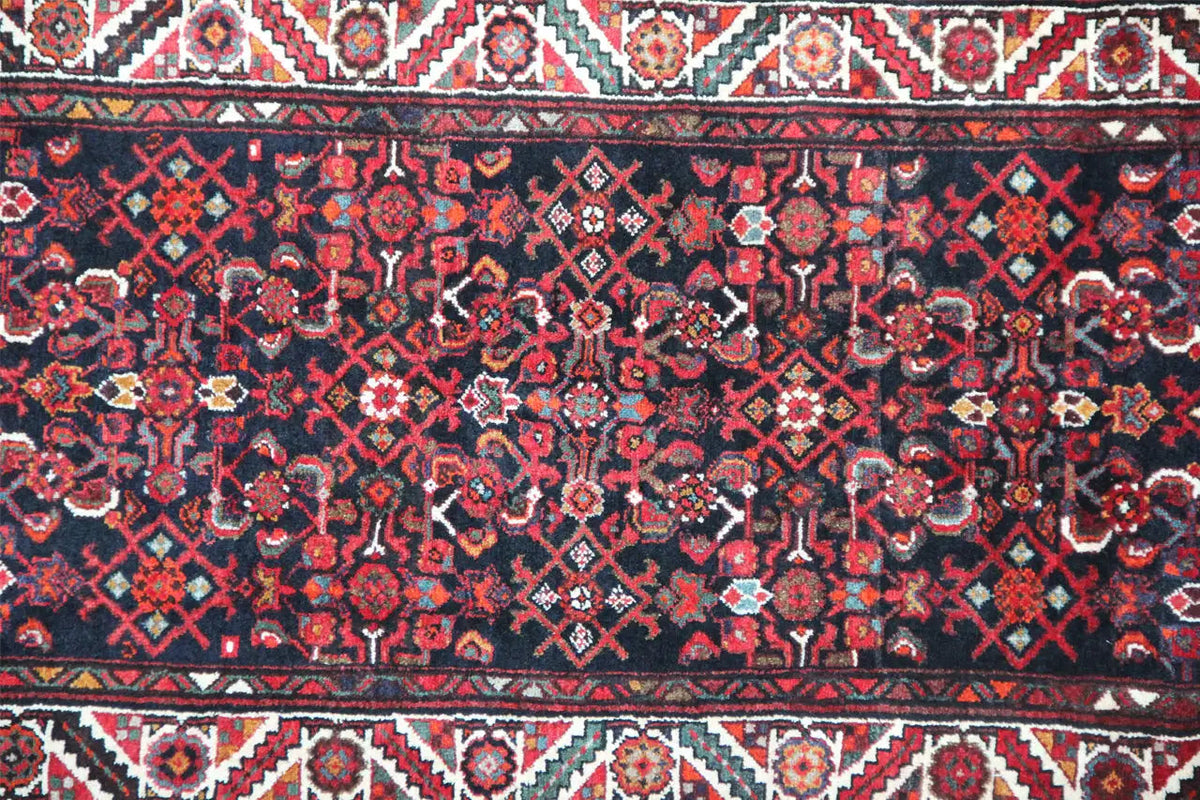 Detail view of the Oriental rug pattern: dark red, blue, and ornaments