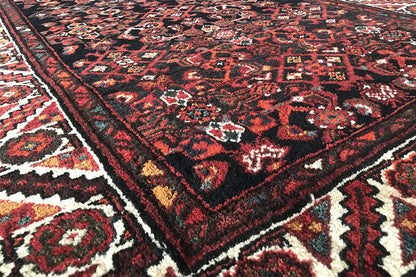 Close-up of the carpet pattern: dark red, black, and beige accents
