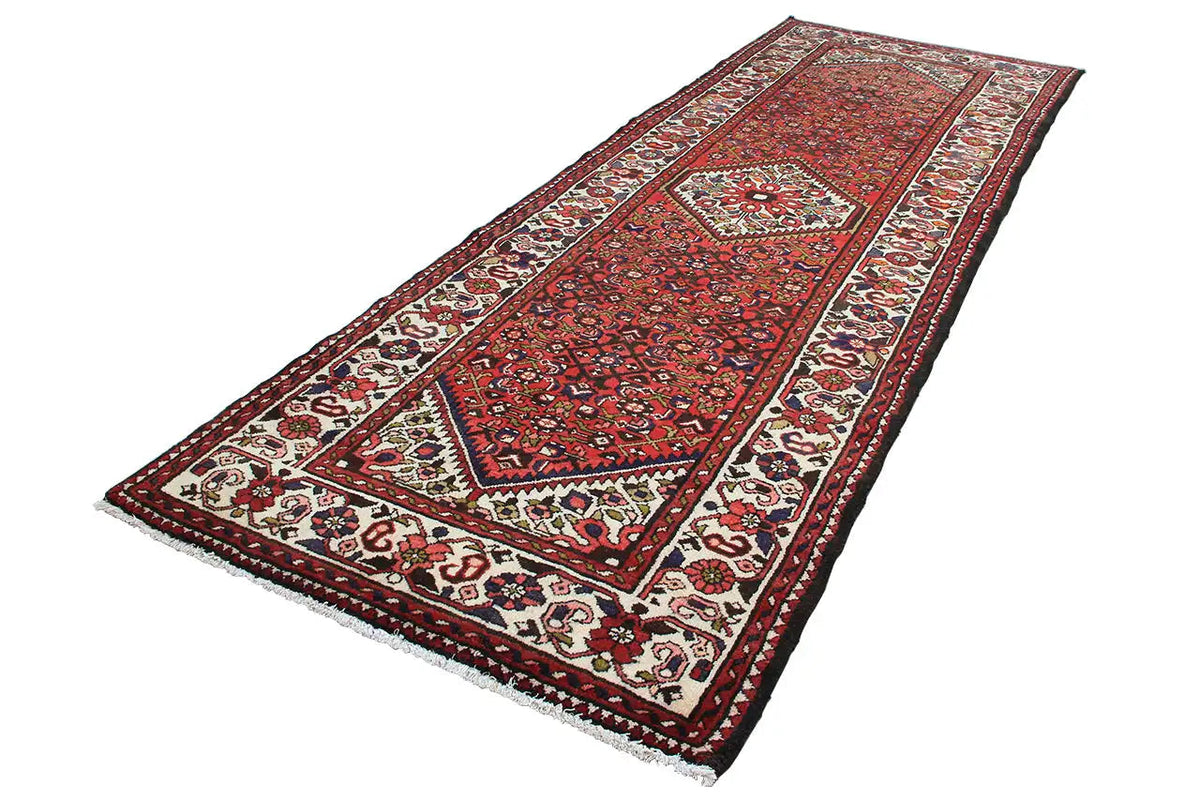 Red runner with a border and central medallion design in a traditional pattern