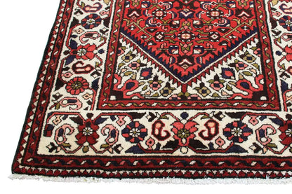 Detailed view: red runner with floral ornaments and a patterned border trim