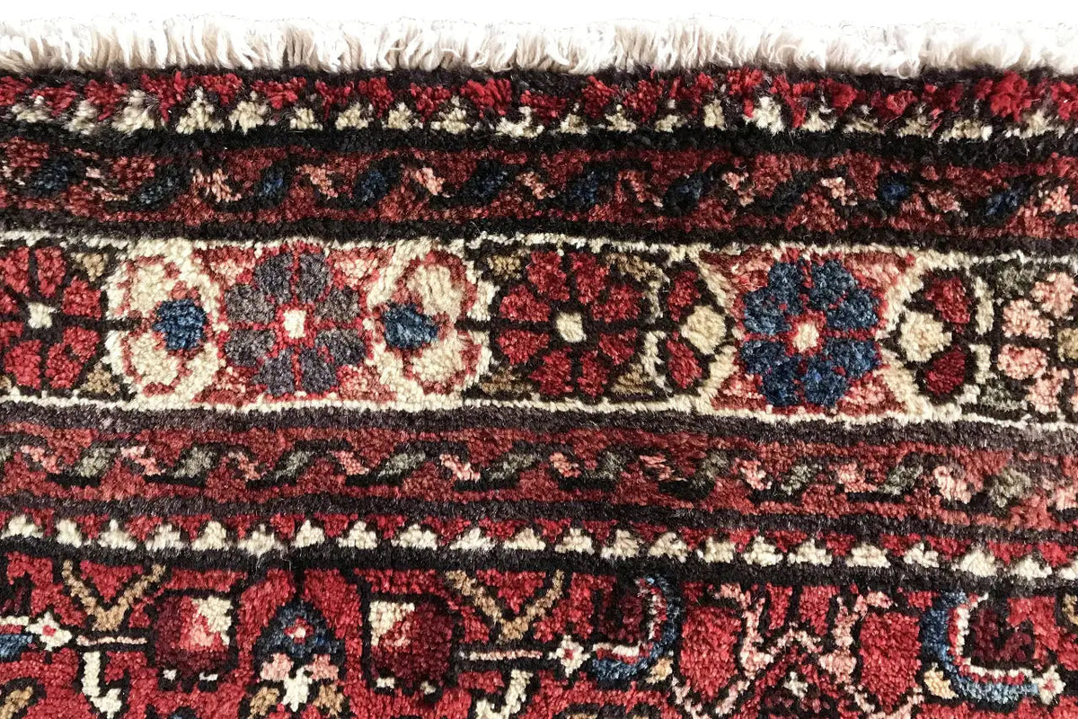 Hamadan runner detail: fringes and dense pile with red, beige, and dark blue patterns