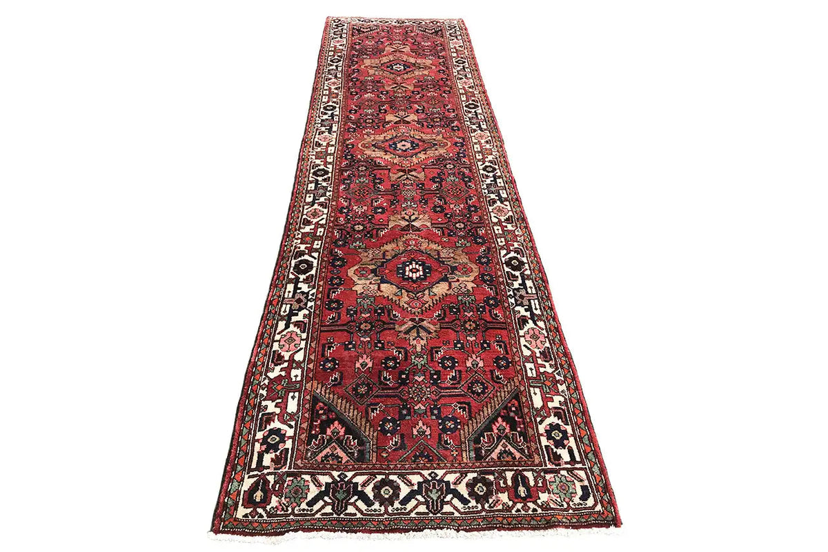 Oriental runner with a red background, a wide border design, and delicate ornaments