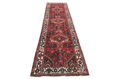 Oriental runner with a red background, a wide border design, and delicate ornaments
