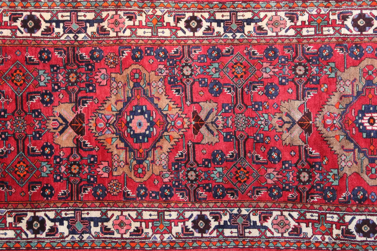 Detailed view: red runner with geometric ornaments, medallions, and a border