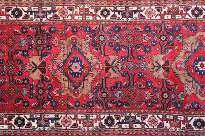 Detailed view: red runner with geometric ornaments, medallions, and a border