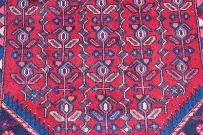 Detailed view of Hamadan runner: red background with blue and red ornamental embroidery patterns