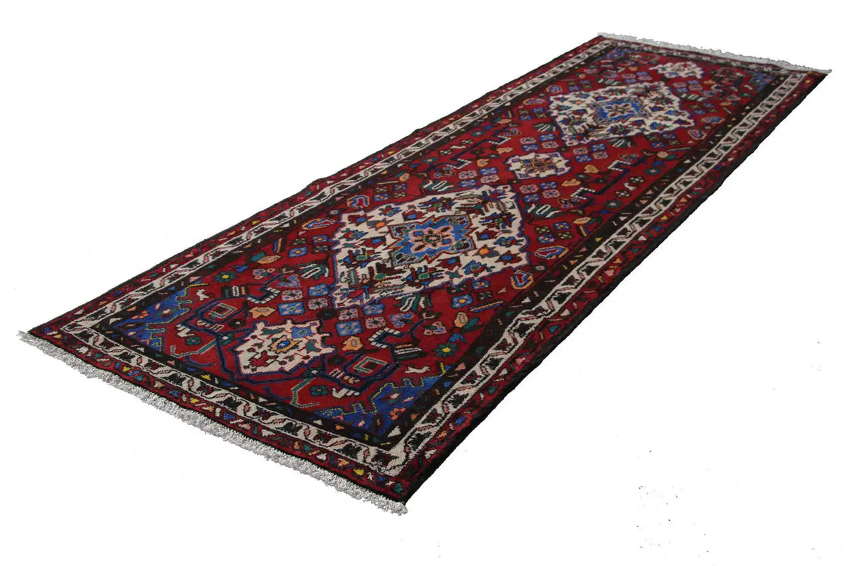 Hamadan runner with a red background, blue-and-white patterns, and a dark decorative border