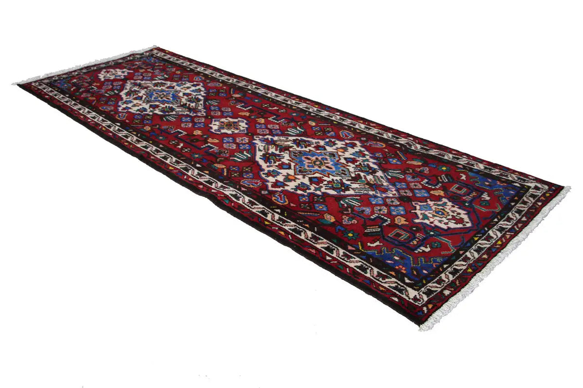 Hamadan rug with a red background, multicolored pattern, and framed border