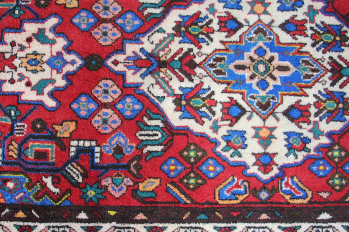 Close-up of a Hamadan rug runner: red pattern with blue, white, and yellow ornaments