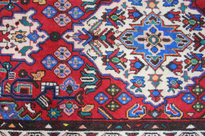 Close-up of a Hamadan rug runner: red pattern with blue, white, and yellow ornaments