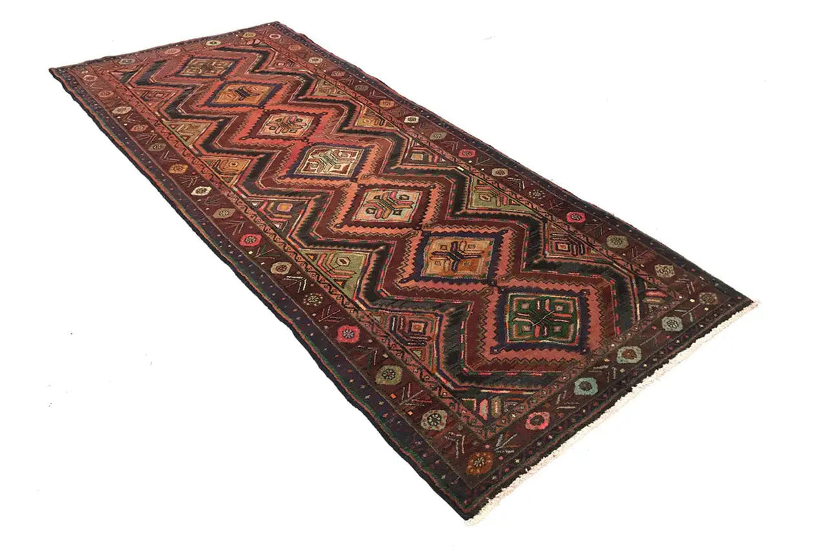 Oriental rug runner with twisted zigzag and medallion patterns in red and dark brown