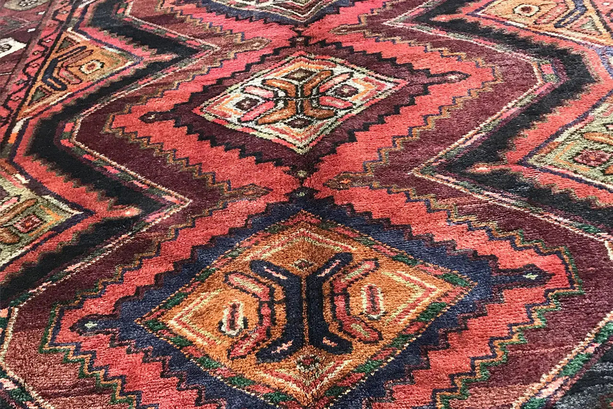 Detail of the Oriental rug runner: geometric patterns in red, brown, green, and beige