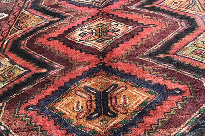 Detail of the Oriental rug runner: geometric patterns in red, brown, green, and beige