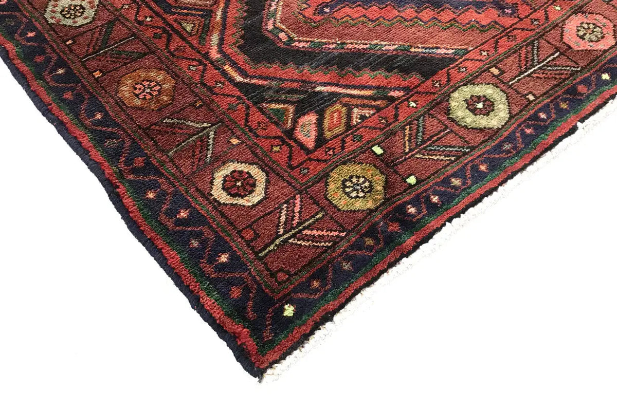 Corner view of the Oriental runner rug with a geometric pattern and multicolored border