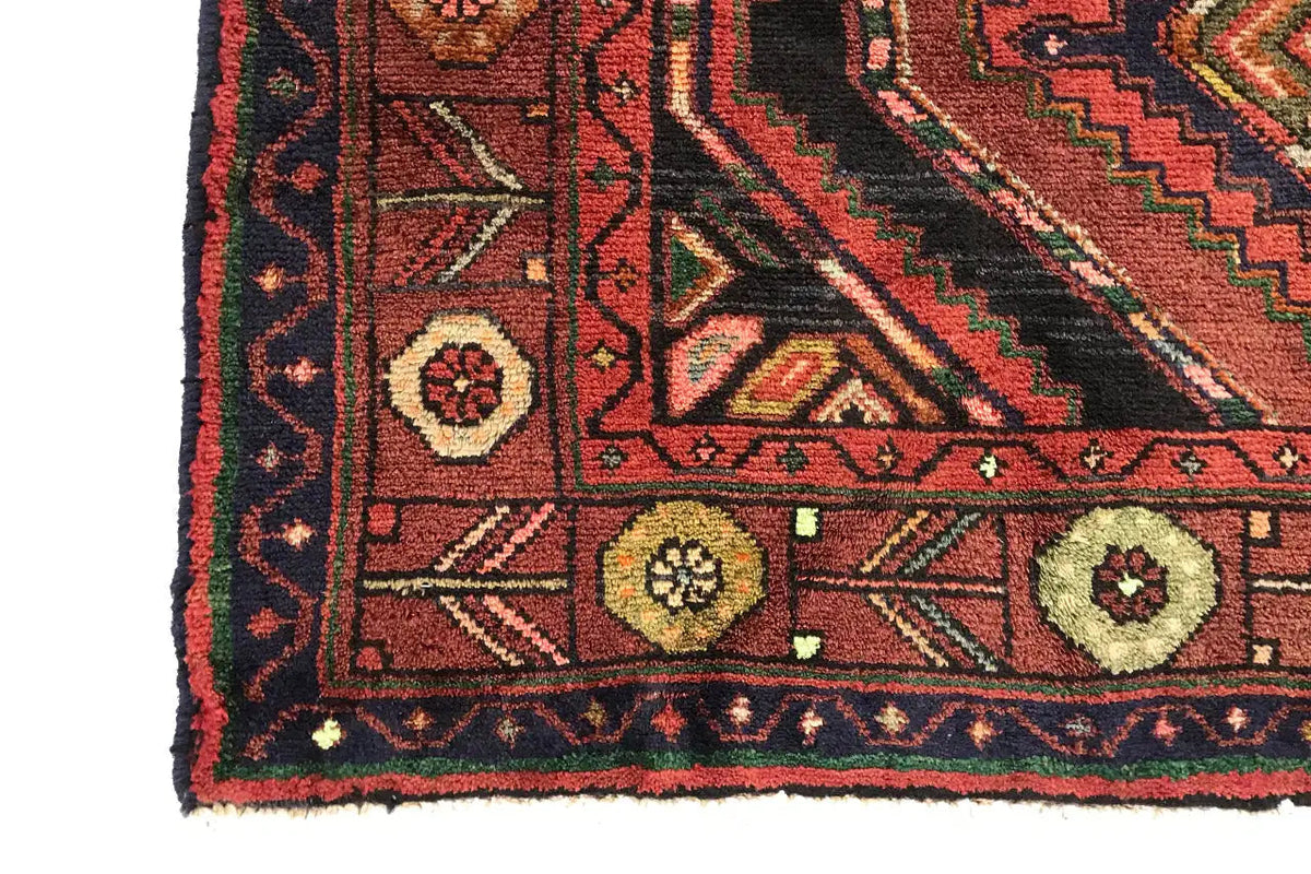 Close-up of the carpet edge: diamonds, ornaments, and decorative border in red, green, and beige