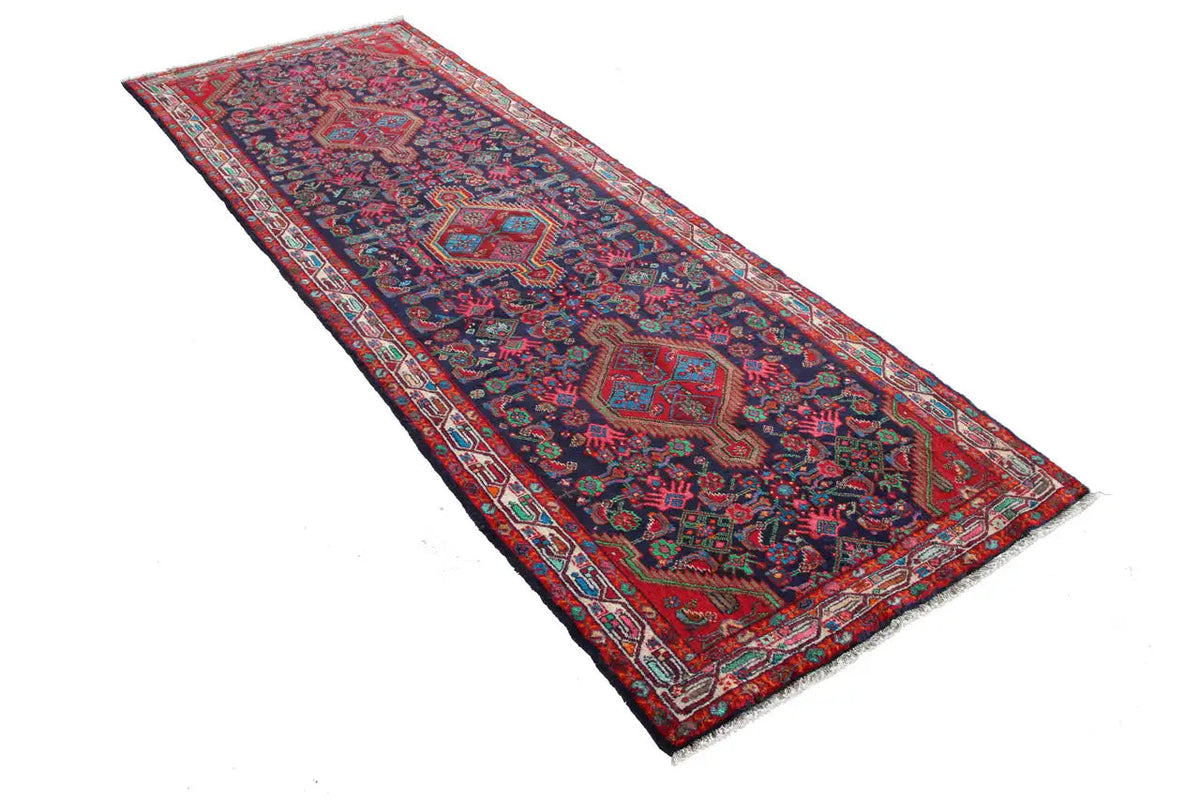Oriental rug runner with a geometric pattern in blue, red, green, and beige details