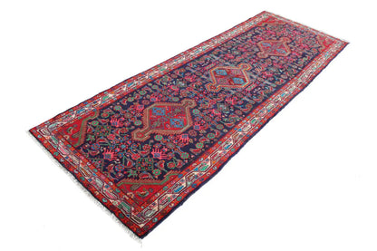 Oriental rug runner lying flat with a colorful medallion design in blue and red