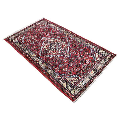 Hamadan rug on a diagonal cut: red, intricately detailed medallion pattern