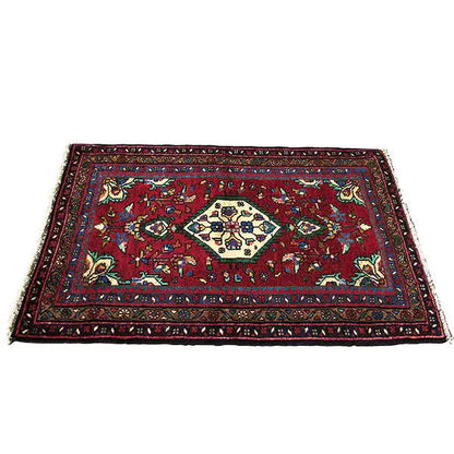 Oriental rug with a red background, ornamental pattern, and narrow border border