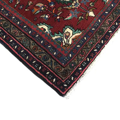 Rug corner with red, green, and blue ornaments and fringes along the edge