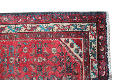 Hamadan runner border detail with a red ground, border, and multicolored pattern.
