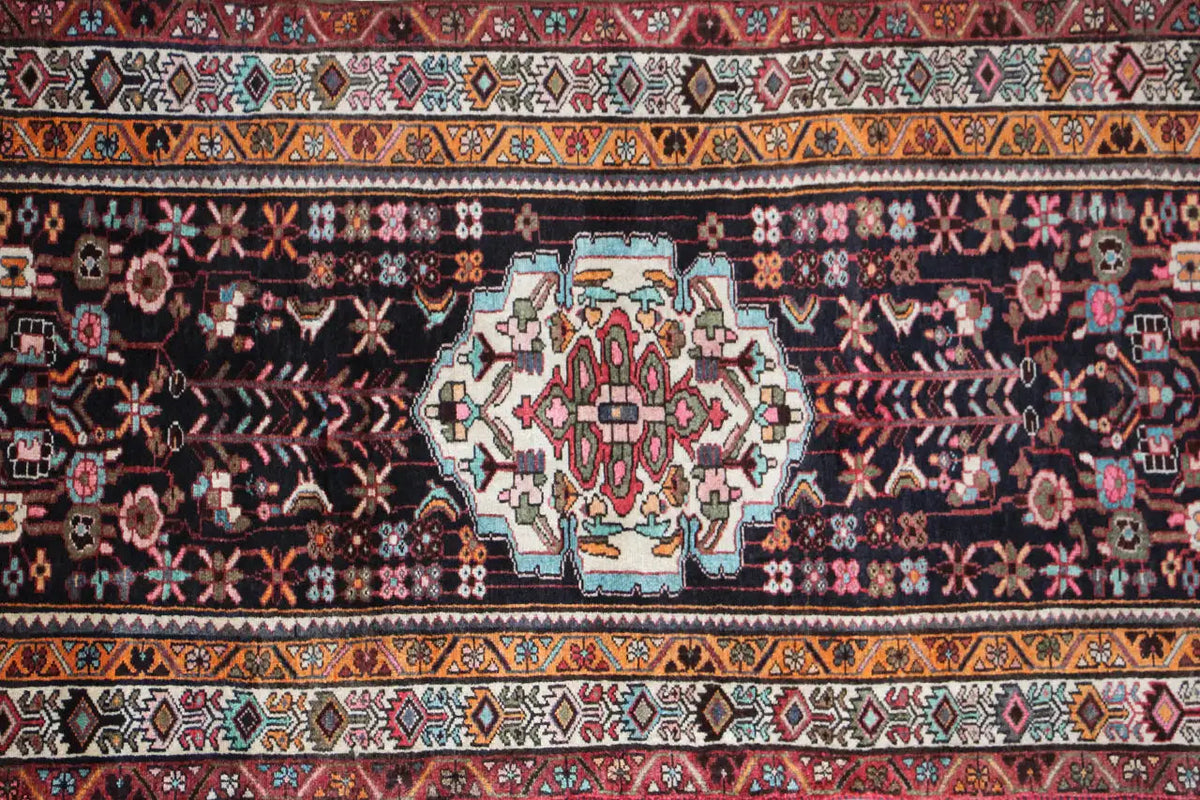 Oriental rug runner with a central medallion and geometric pattern, dark background