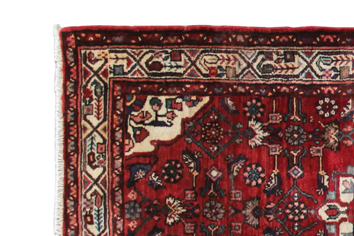 Hamadan runner with a red pattern and woven border detail along the edge