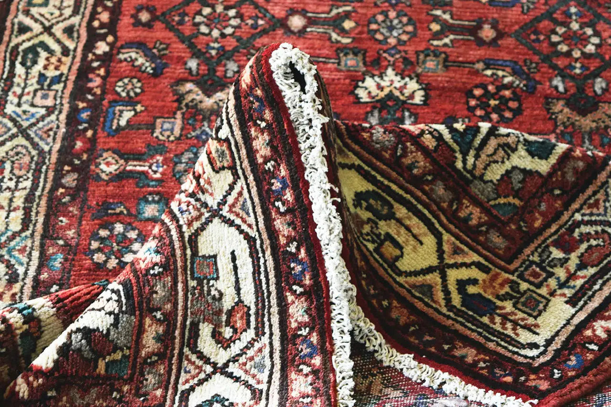 Hamadan runner corner with fringe and an ornamental pattern in red, blue, and cream