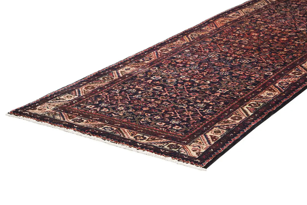 Runner with a diagonally tapering border and intricate ornamental pattern on a dark background