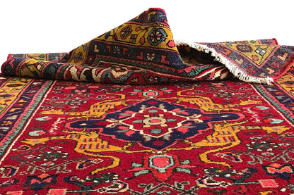 Red-and-variegated patterned Oriental runner rug with border, rolled edge, and fringe