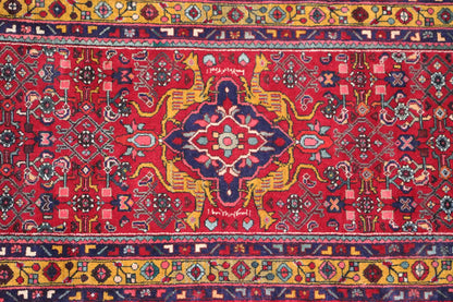 Close-up: red multicolored Oriental rug runner with a central medallion and border