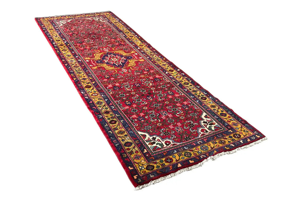 Red Oriental runner rug with blue-yellow borders, rectangular, with fringes