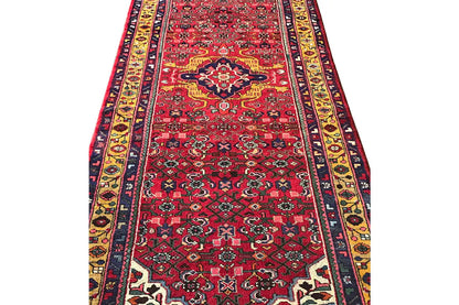 Red-and-multicolor oriental runner rug with a longitudinal border, delicate pattern, and fringes
