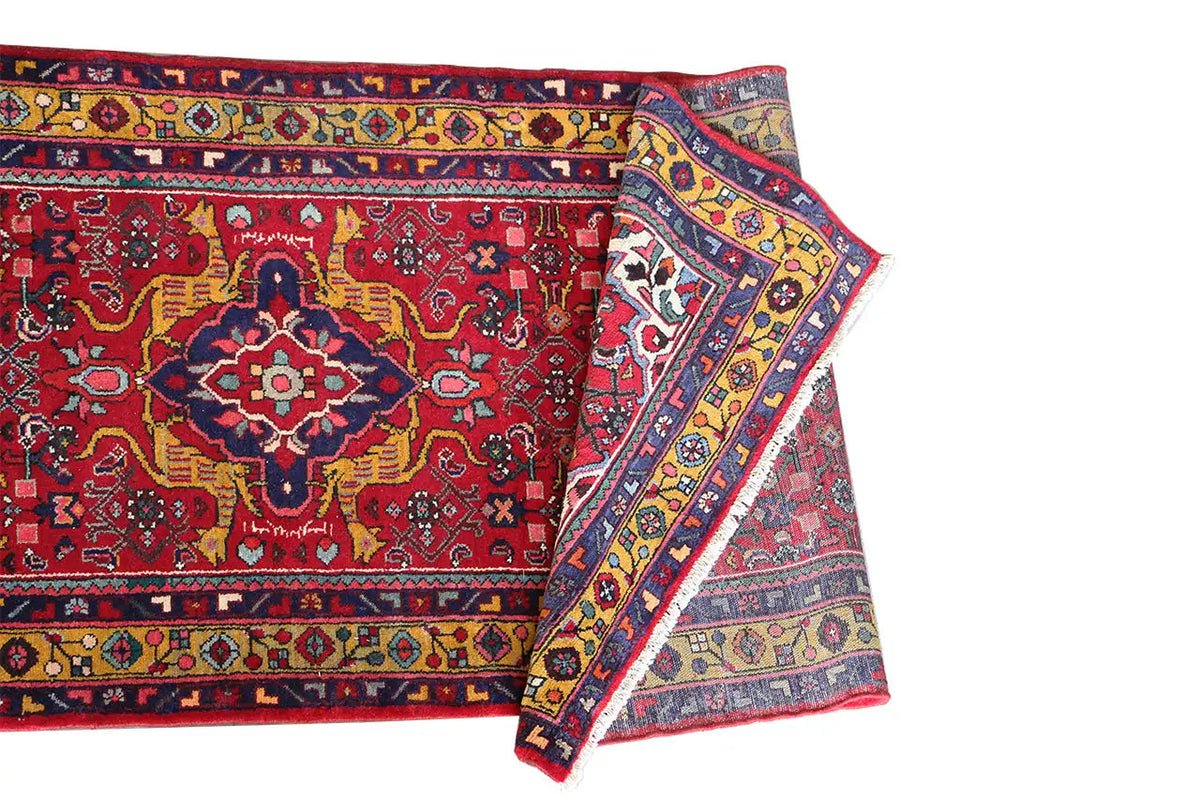 Two overlapping edges on the red-and-multicolored Oriental rug runner with border