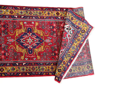 Two overlapping edges on the red-and-multicolored Oriental rug runner with border