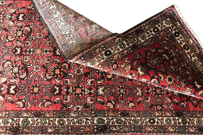 Oriental rug runner, red and black, with ornaments and a wide border along the edge