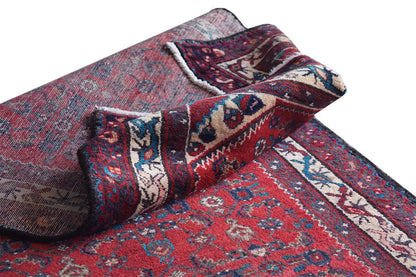 Oriental rug runner with twisted edge, red ornamental pattern, and blue-and-white borders