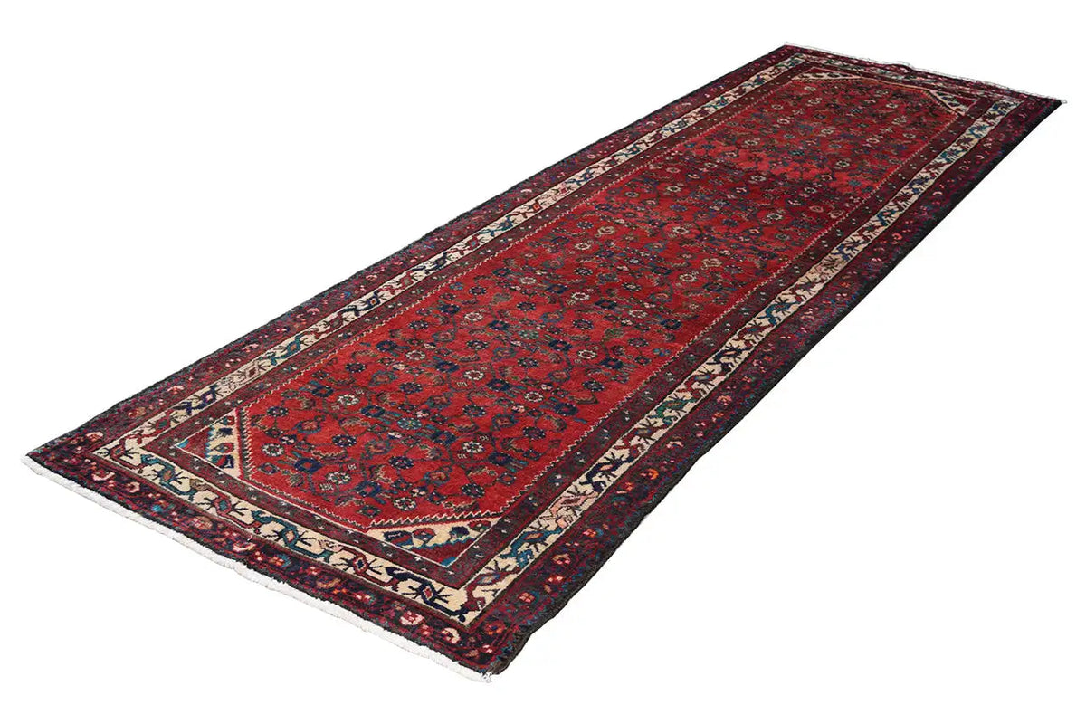 Red oriental runner rug with ornamental rows and contrasting blue-and-white decorative stripes