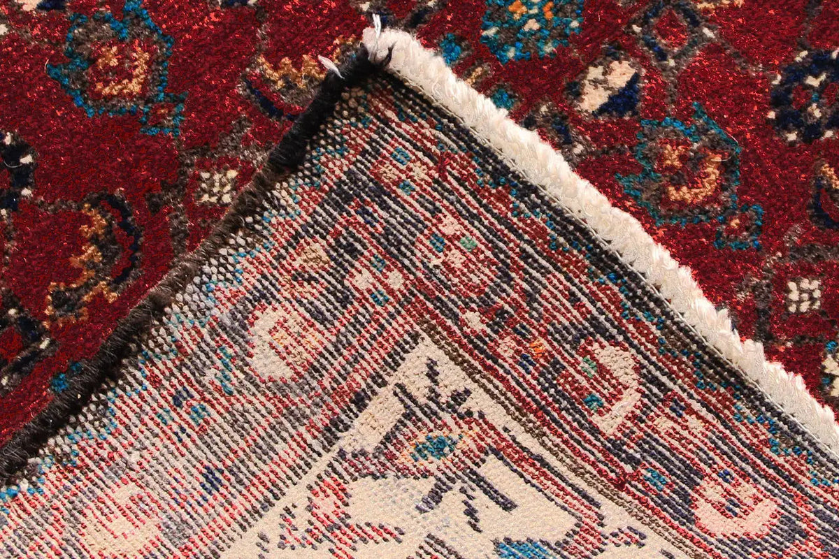 Detail of the carpet edge: dense pile along the edge of a red oriental pattern with fringes