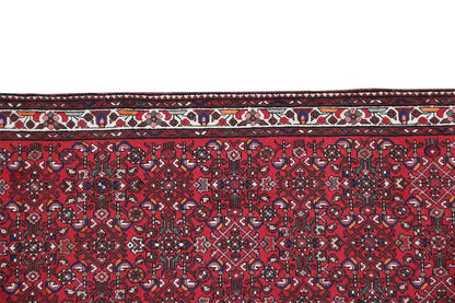 Close-up: red runner carpet with a dense ornamental design and a border all around