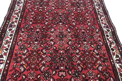 Close-up: Red carpet runner with a small-scale pattern and contrasting border bands