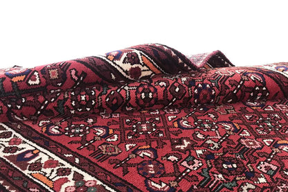 Red runner in a gentle wave shape, with detailed ornamentation and a bordered edge