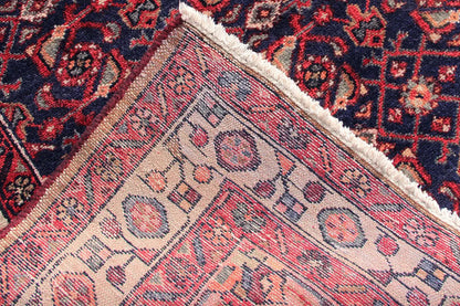 Oriental rug runner, detail of the weave structure: beige background, blue-red patterns along the edge